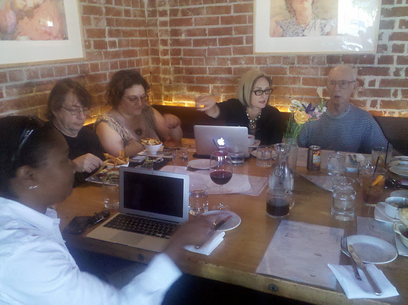 Faculty meeting at a bar and grill and talking around a table. 